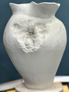 Pottery vase with a flower motive in the greenware stage.